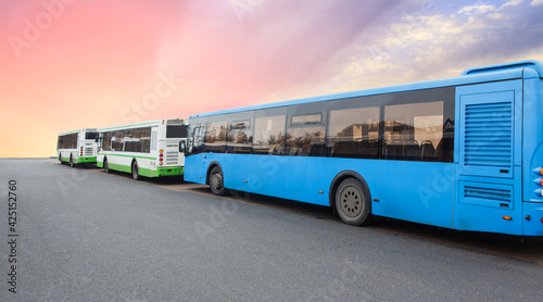 Buses in a row against the background of sky at sunrise