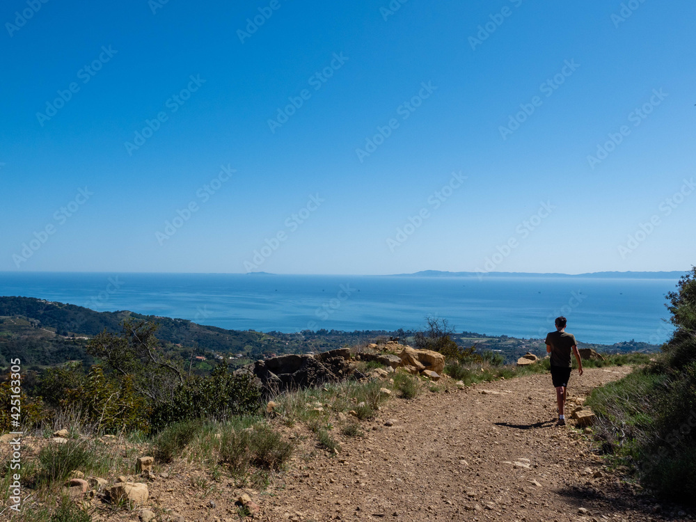 Hiker admiring view from Old Romero Canyon Trail in Montecito, California near Santa Barbara on a clear, sunny spring day