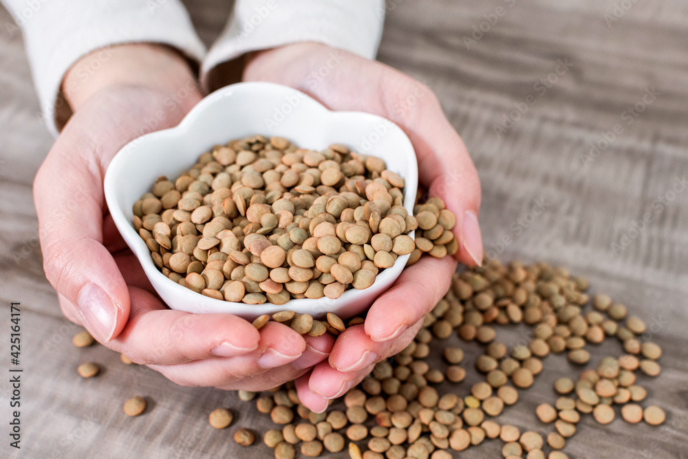 Close-up Of Hands holding bowl with raw lentils. Close-up Of Hands holding bowl with raw lentils.