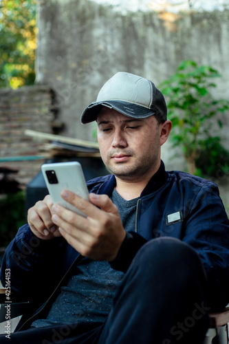 hombre con gorra usando el movil tranquilamente 