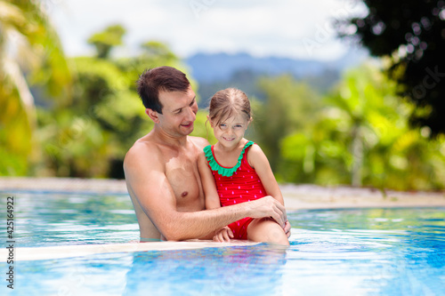 Father, child at swimming pool. Dad and kid swim.