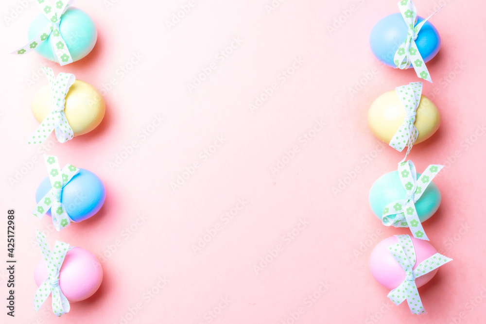 Easter egg hunt. Colorful egg with tape ribbon on pastel pink background in Happy Easter decoration. Traditional design in top view.