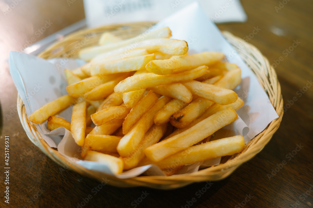French fries on plates and blotting papers.soft light with Vintage tone. French fries on plates and blotting papers.soft light with Vintage tone.