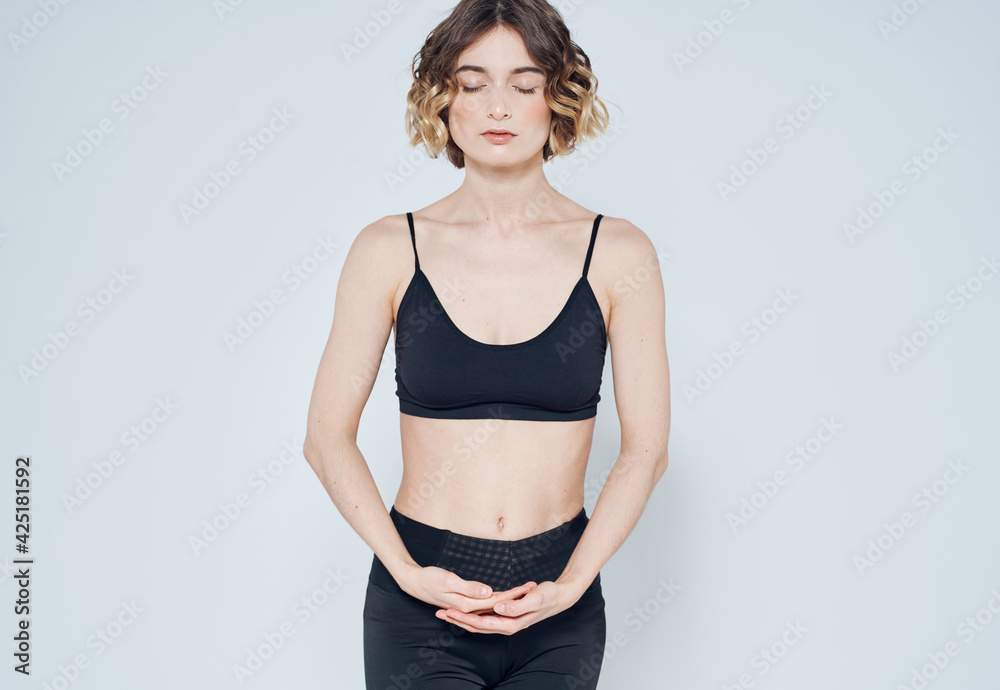 Woman in sportswear is engaged in fitness on a light background cropped view - obrazy, fototapety, plakaty 