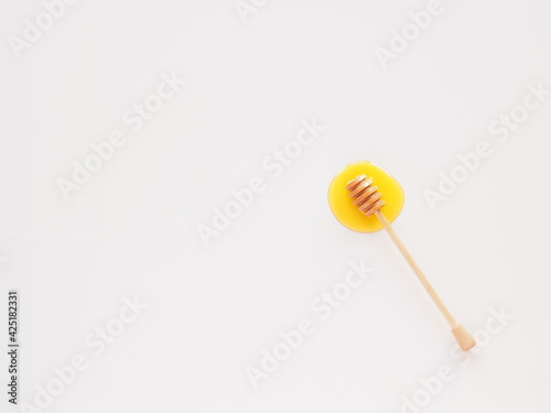 Honey splash with wooden dipper, flat lay isolated on white
