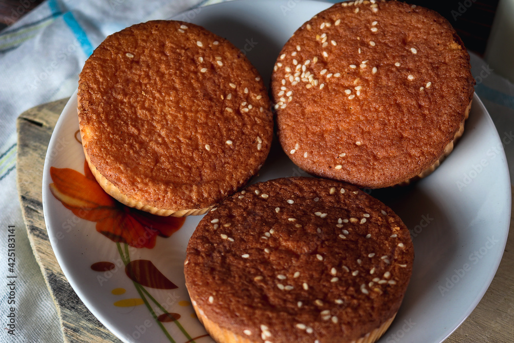 Fotos de Cupcakes acabados de hornear con un vaso de leche en el fondo y en una mesa rustica. 