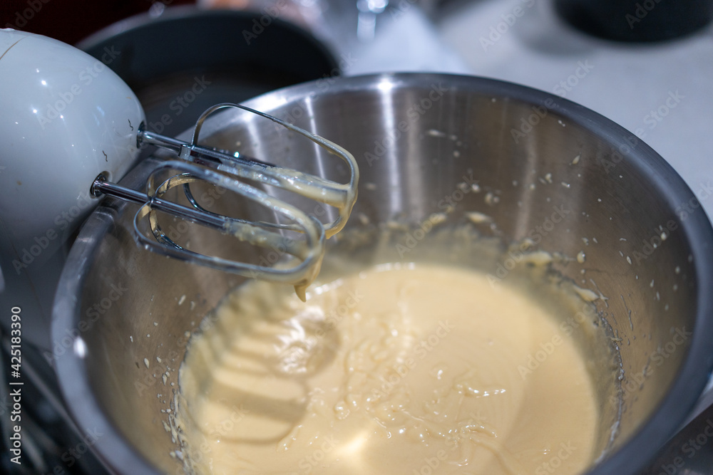 child baking in the kitchen, using electric beater making a cake
child baking in the kitchen, using electric beater making a cake