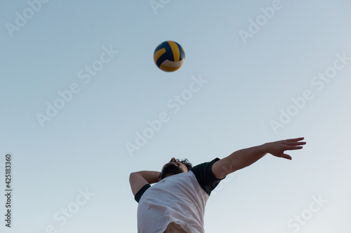 young man jumping playing volleyball