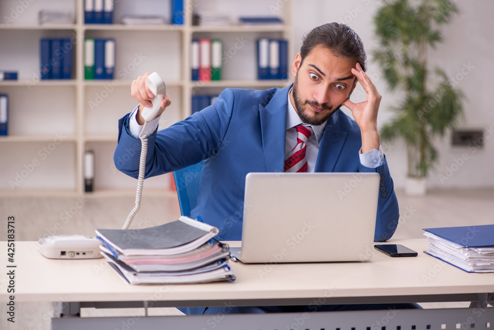 Young male employee working in the office Young male employee working in the office