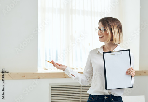 Woman rooming near window interior Folder with documents white sheet of paper 