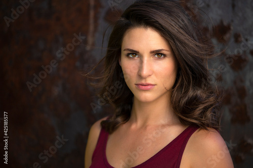 Beautiful portrait head shot of a serious and confident pretty brunette woman with an empowered strong passionate gaze