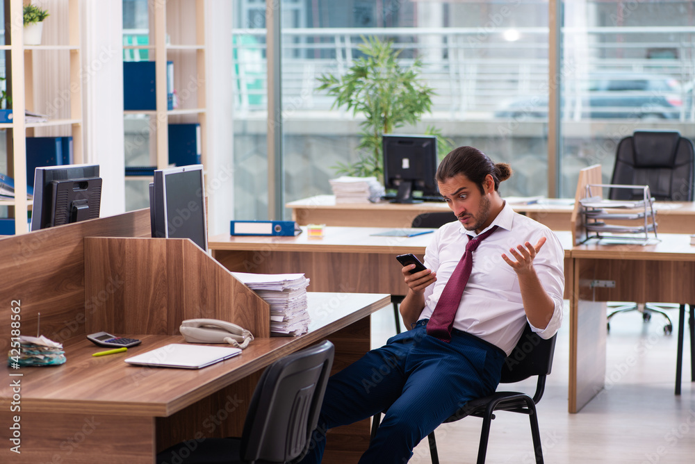 Young male employee and too many work in the office Young male employee and too many work in the office