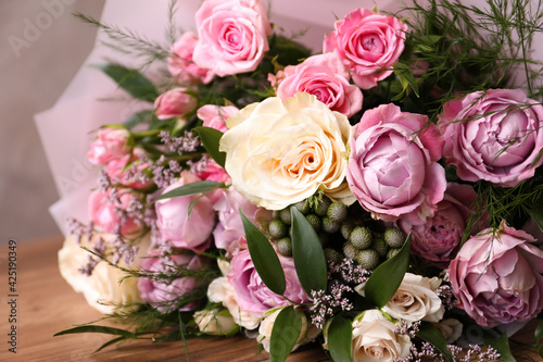 Beautiful bouquet with roses on wooden table  closeup