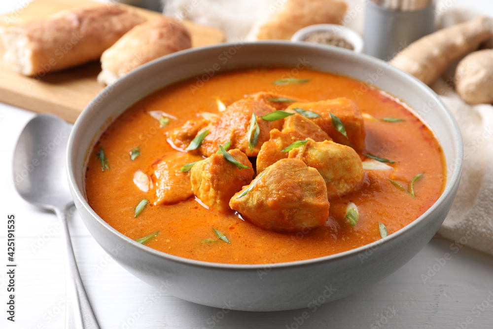 Bowl of delicious chicken curry on white table Bowl of delicious chicken curry on white table