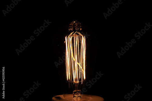 Closeup of light bulb against on black background.