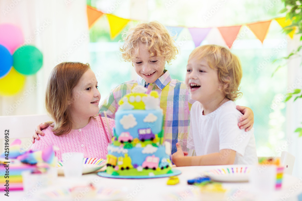Kids birthday party. Child blowing out cake candle Kids birthday party. Child blowing out cake candle