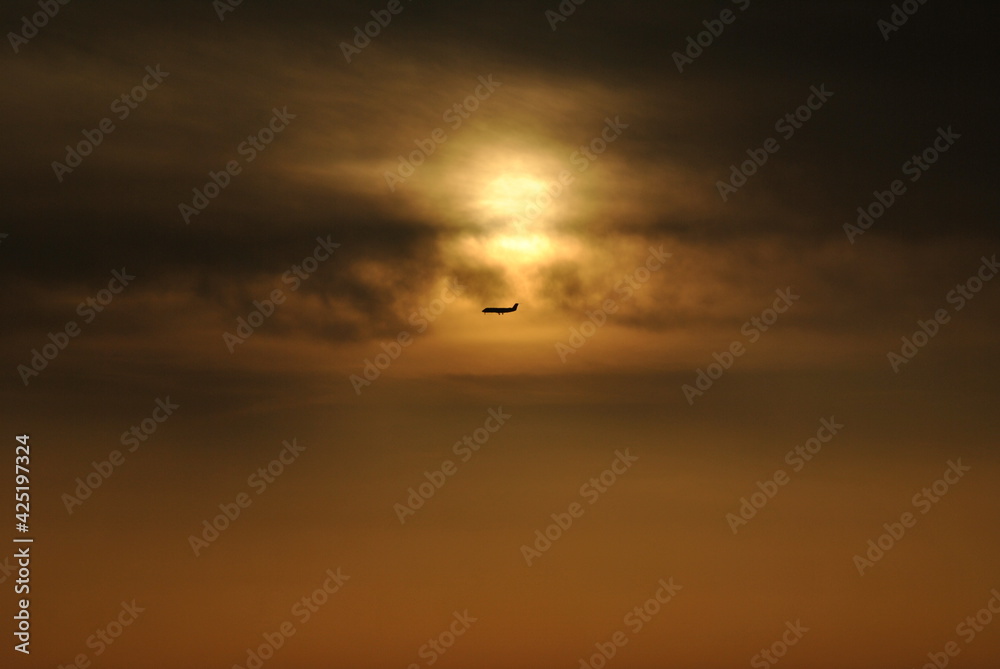 Fototapeta premium sunset in the sky with an airplane