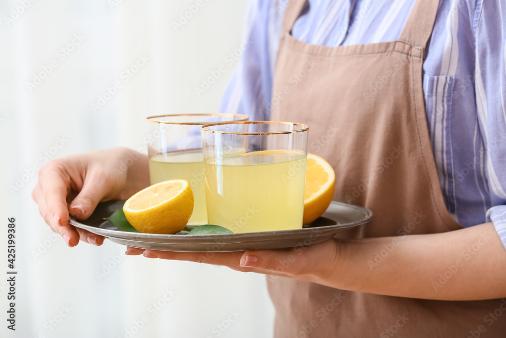 Woman with glasses of lemon juice, closeup Woman with glasses of lemon juice, closeup