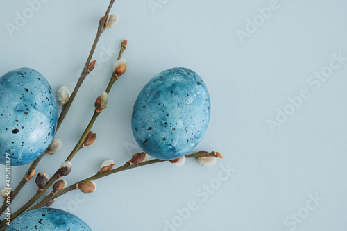Easter bouquet of blue Easter eggs and pussy willow branches on a pastel blue background with place for text, top view, flat lay. Spring easter concept