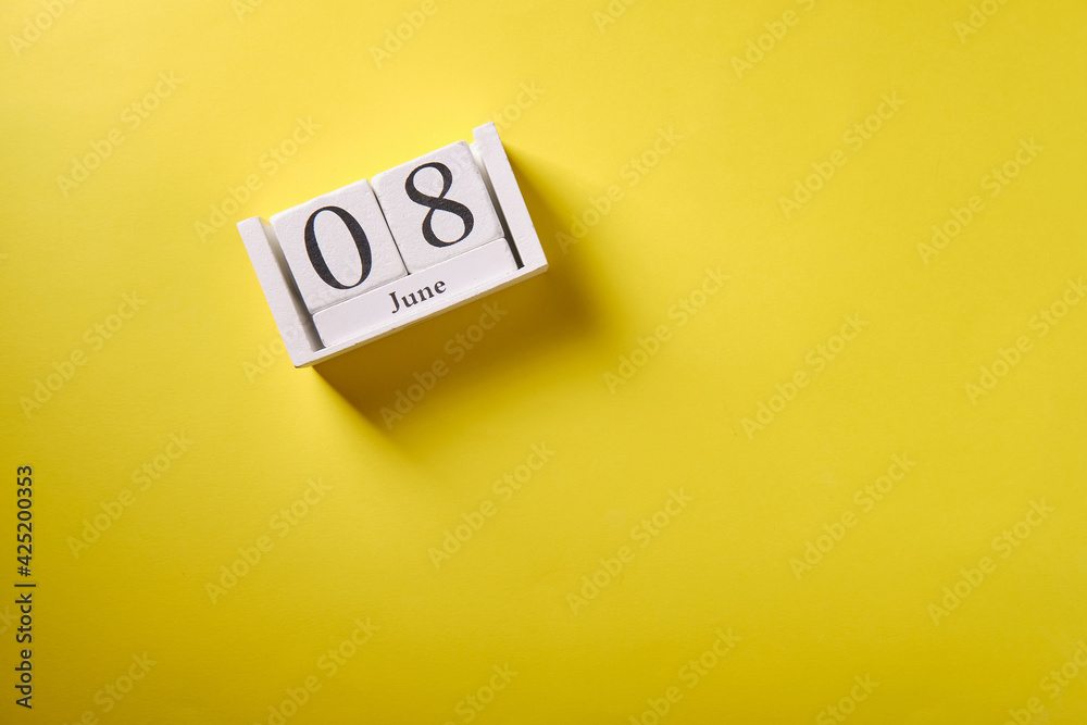 Wooden calendar on yellow background, top view, date 8 June Wooden calendar on yellow background, top view, date 8 June