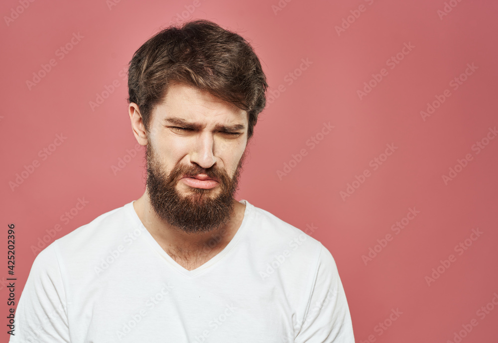 Man on pink background emotions model cropped view puzzled look sad face Man on pink background emotions model cropped view puzzled look sad face