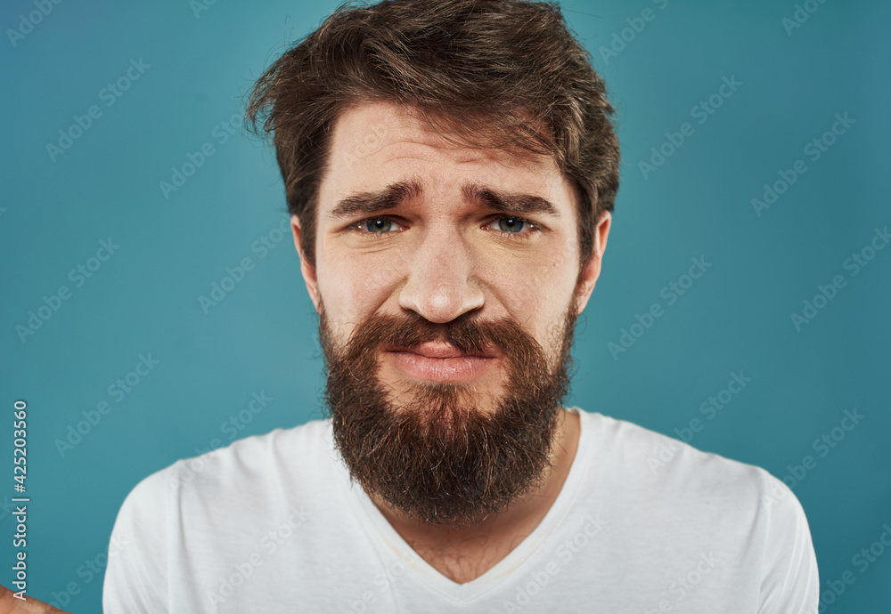 portrait of a sad brunette man on a blue background cropped view portrait of a sad brunette man on a blue background cropped view