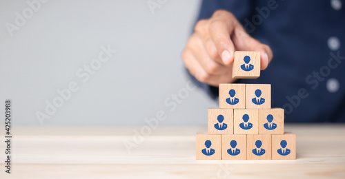 Concept of human resource management and recruitment business Hand put wood cube block on top pyramid To business success concept.