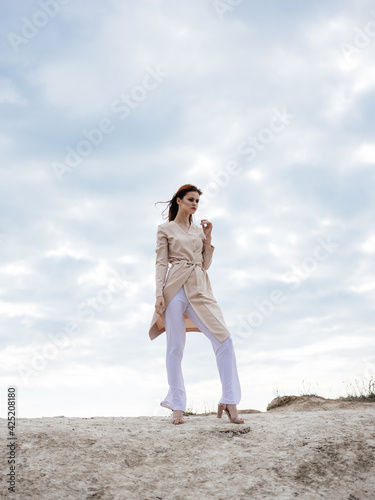 Woman in light clothes outdoors clouds blue sky sand