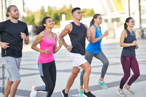 Happy group of sporty people training in the city