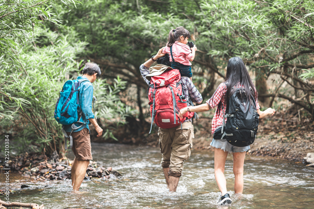 A group of young Asians are planning and looking at maps for camping in the forest.Asian and caucasian are backpackers.Tourism, adventure and summer vacation concept A group of young Asians are planning and looking at maps for camping in the forest.Asian and caucasian are backpackers.Tourism, adventure and summer vacation concept