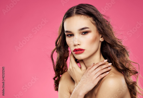 Woman model brunette on pink background bare shoulders cropped view