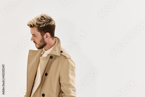 a man in a beige coat fashion studio modern style look aside Copy Space