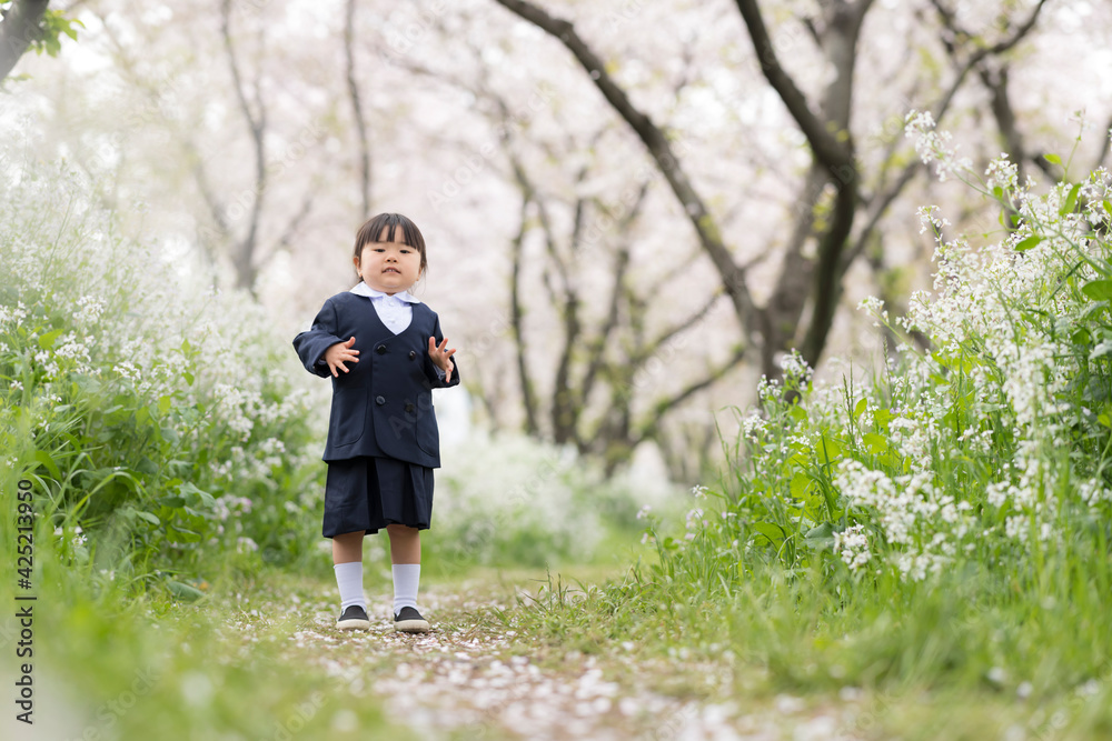 桜の並木を走るの幼稚園児
