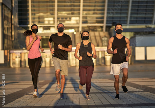 Friends in sportswear and face masks while jogging