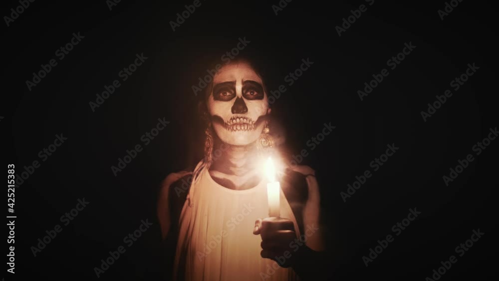 Catrina Girl Candles day of the dead in mexico 2 4k.mov	light, spiritual, makeup, dark, woman, candles, candle, fire, candlelight, flame, face, people, black makeup, chandelier, body painting, body pa
