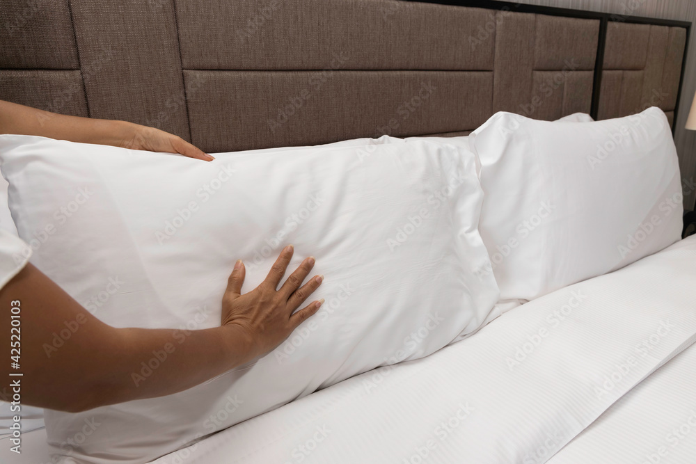 Selective focus of woman hand maid making the bed with clean fresh in room