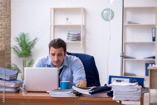 Young male employee suffering at workplace