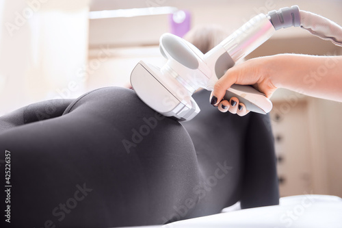 Woman receives LPG massage to remove cellulite from her body  for lifting legs. Concept beauty therapy in spa salon