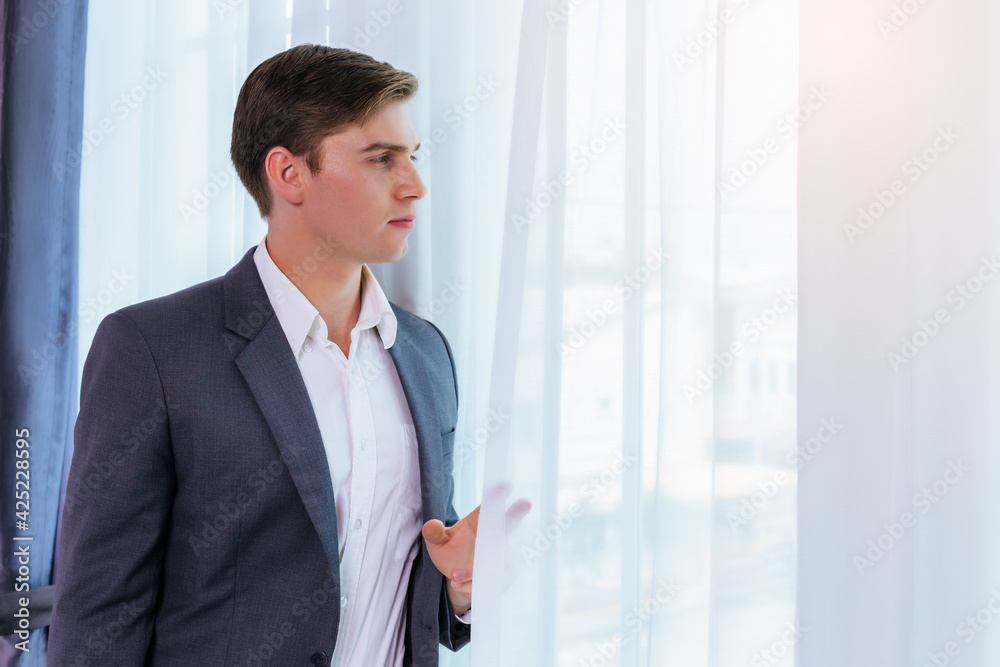Confident business man stand near window at office wearing suit and shirt Portrait Handsome young Caucasian businessman He is English guy Gentlemen Male look though window Attractive men stay at home Confident business man stand near window at office wearing suit and shirt Portrait Handsome young Caucasian businessman He is English guy Gentlemen Male look though window Attractive men stay at home