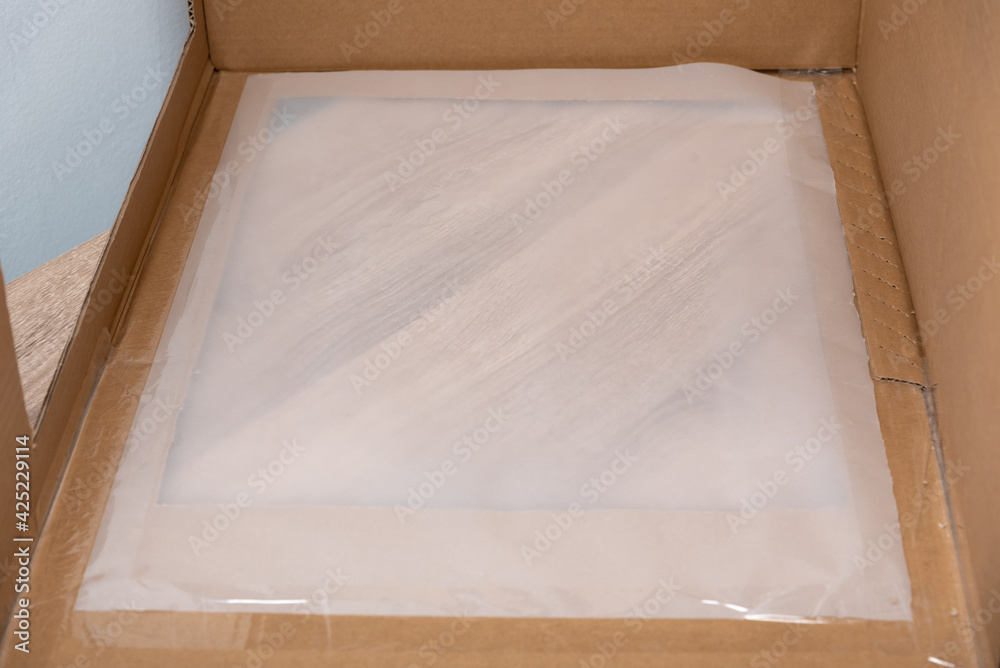 Tissue paper sheet pasted to carton box with shipping tape