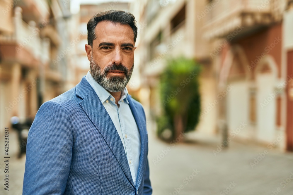 Middle age businessman with relaxed expression standing at the city. Middle age businessman with relaxed expression standing at the city.
