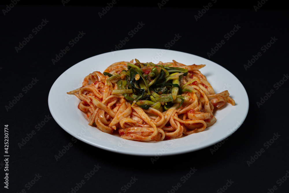 Spaghetti in tomato sauce on a dark background. Spaghetti with a vegetable side dish on a black background. Italian food. Tasty food Spaghetti in tomato sauce on a dark background. Spaghetti with a vegetable side dish on a black background. Italian food. Tasty food