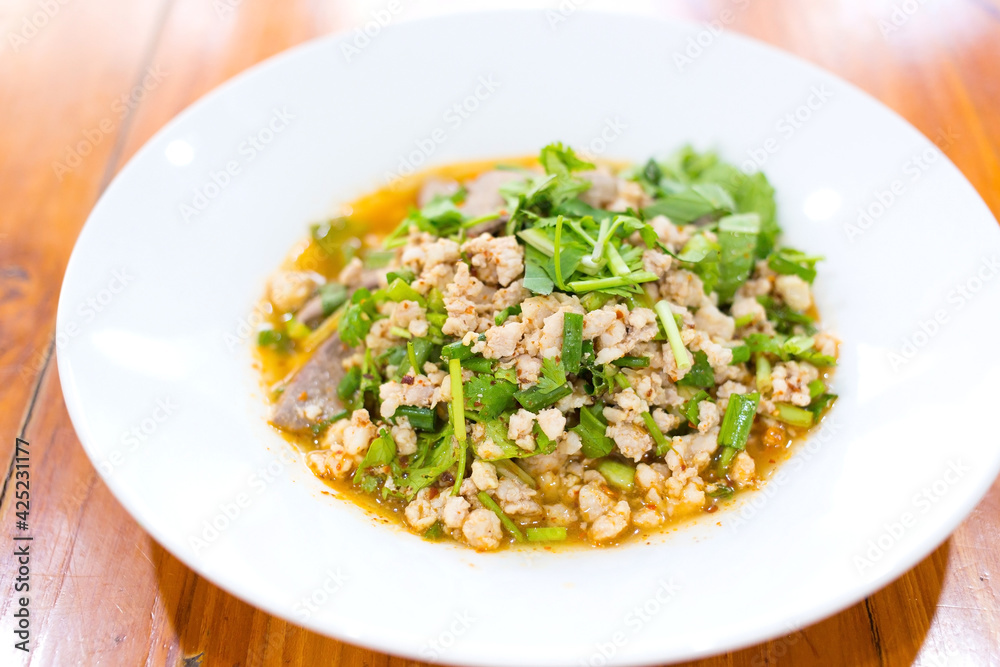 Spicy minced pork salad is traditional food of Northeast of Thailand. It contains minced pork, roasted rice, roasted chili and Thai herbs mixed together. It was put on white plate. Spicy minced pork salad is traditional food of Northeast of Thailand. It contains minced pork, roasted rice, roasted chili and Thai herbs mixed together. It was put on white plate.