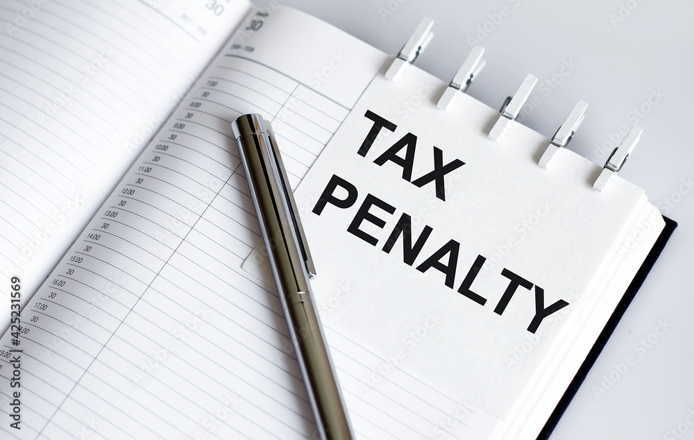 text TAX PENALTY, on the short note texture background with pen text TAX PENALTY, on the short note texture background with pen