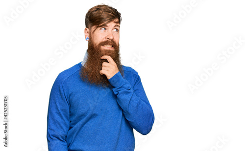 Young irish redhead man wearing casual clothes with hand on chin thinking about question, pensive expression. smiling with thoughtful face. doubt concept. © Krakenimages.com