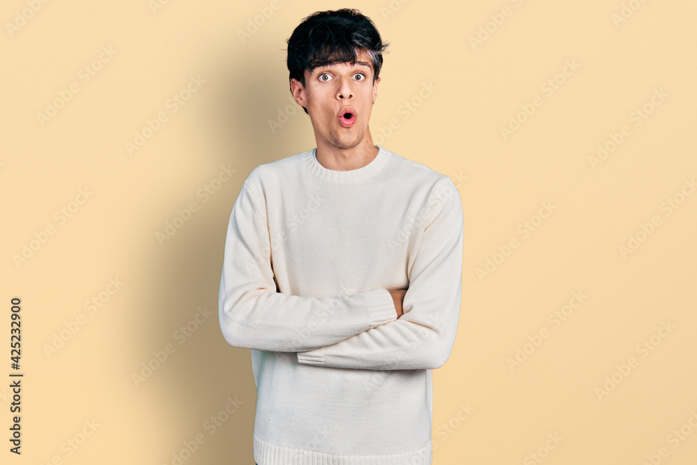 Handsome hipster young man wearing casual winter sweater afraid and shocked with surprise expression, fear and excited face. Handsome hipster young man wearing casual winter sweater afraid and shocked with surprise expression, fear and excited face.