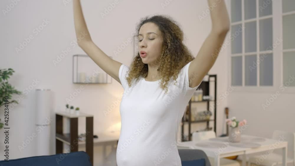 Biracial future mother doing relaxing exercises, practicing yoga at home, sport Biracial future mother doing relaxing exercises, practicing yoga at home, sport