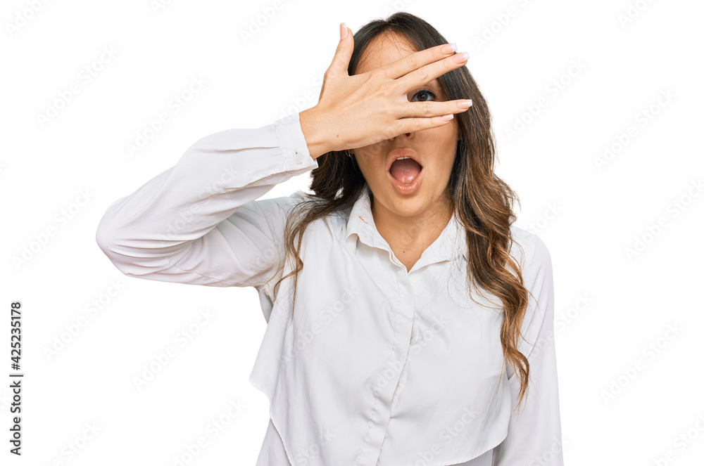 Young brunette woman wearing casual clothes peeking in shock covering face and eyes with hand, looking through fingers with embarrassed expression. Young brunette woman wearing casual clothes peeking in shock covering face and eyes with hand, looking through fingers with embarrassed expression.