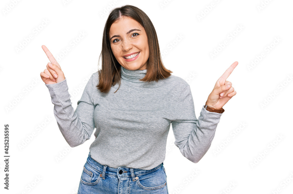 Young beautiful woman wearing casual turtleneck sweater smiling confident pointing with fingers to different directions. copy space for advertisement Young beautiful woman wearing casual turtleneck sweater smiling confident pointing with fingers to different directions. copy space for advertisement