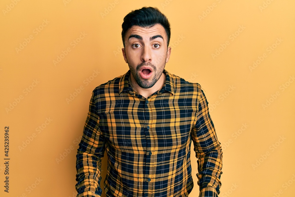 Young hispanic man wearing casual clothes afraid and shocked with surprise and amazed expression, fear and excited face.